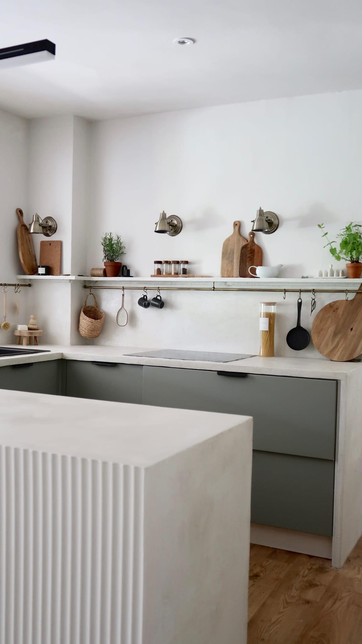 A white kitchen with a fluted wall panelling  breakfast bar