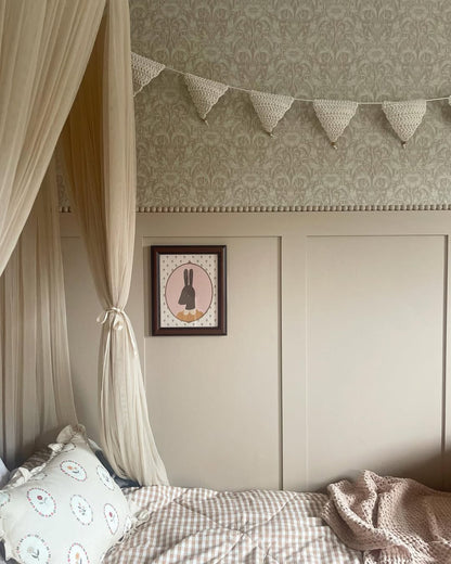 Bedroom with canopy, patterned wallpaper, and framed picture on shaker panelled wall.