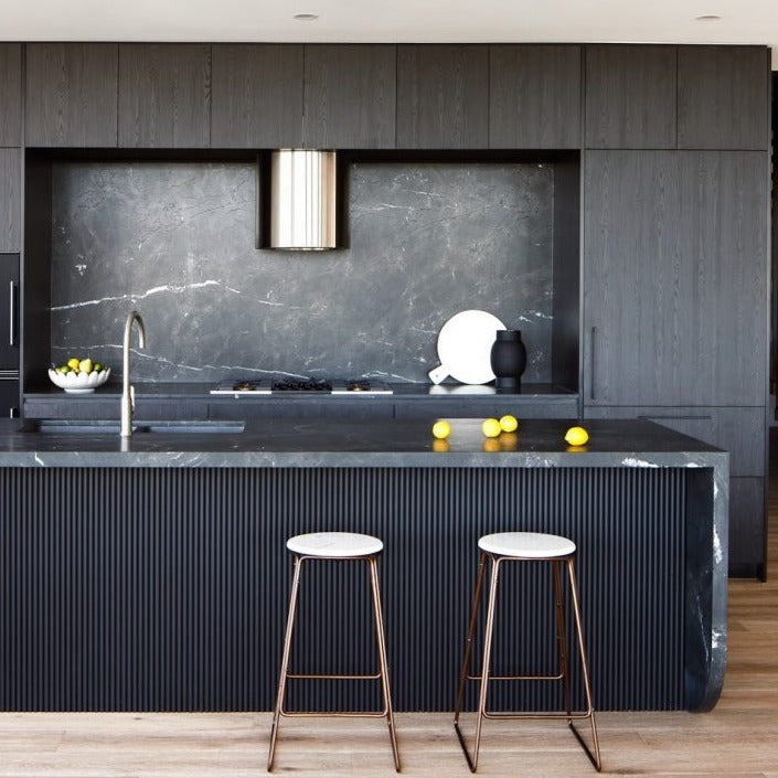 A modern black kitchen with black panelled breakfast bar