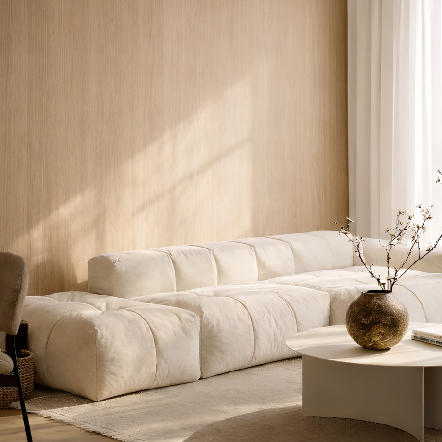 Beige sectional sofa in a oak panelled living room with a small table and decorative vase.