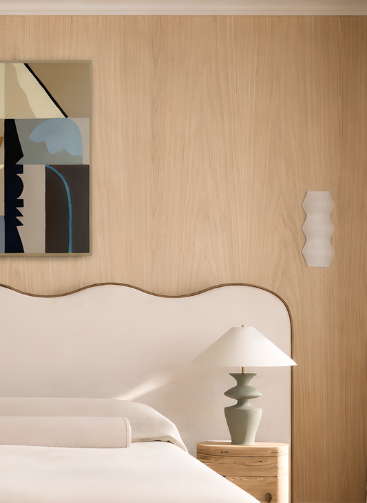 Modern bedroom with oak panelling, abstract painting, and lamp.