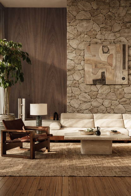 Modern living room with walnut wall stone wall feature, sofa, and decorative items.