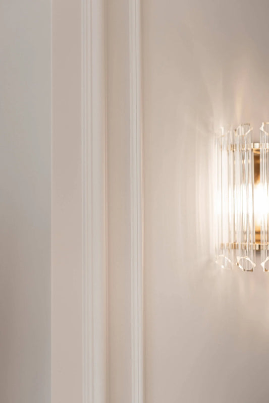 Decorative wall light fixture on a neutral wall with vertical wall panelling