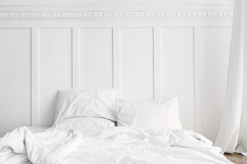 White bedroom with white shaker wall panelling